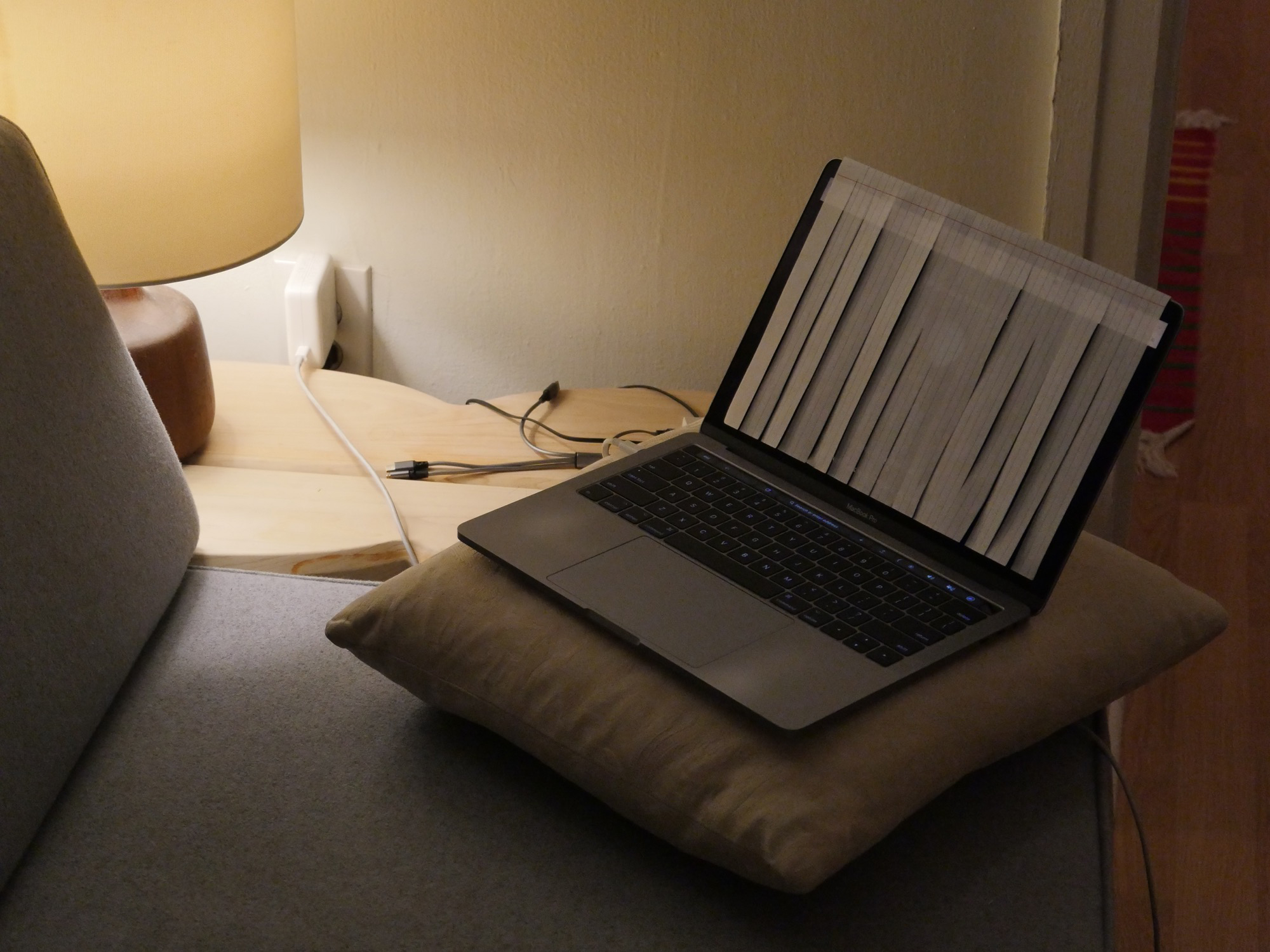 A laptop on a couch with a sheet of paper over the screen.